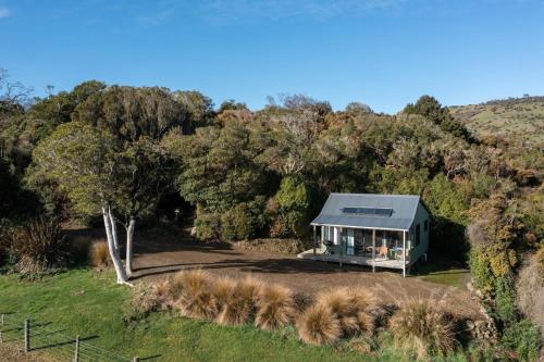 OwakaMohua Park - Catlins Eco Accommodation的森林中间的绿色房子