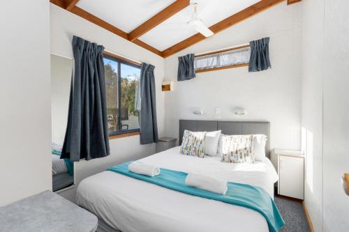 基督城南北度假公园的卧室设有一张白色大床和一扇窗户。