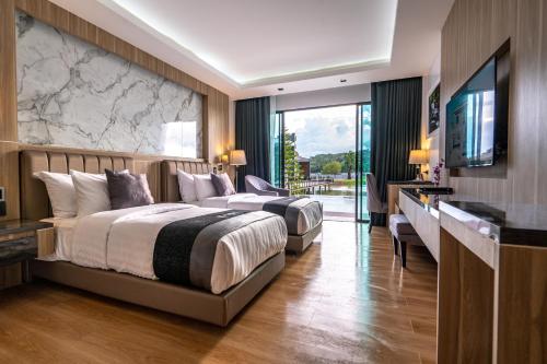 南府Pim Pool Villa Nan的酒店客房设有两张床和电视。