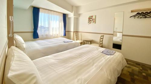 伊势市Toyoko Inn Iseshi Eki的一间卧室设有两张床和窗户。