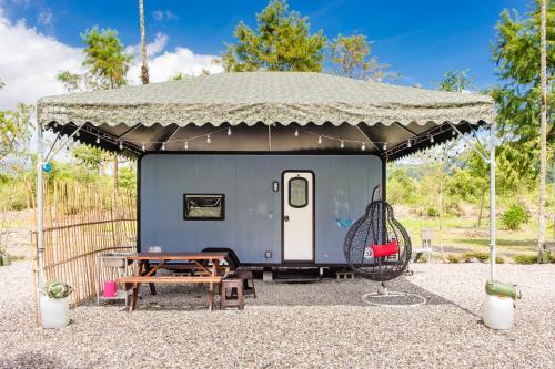 Ta-hsi地热旅居露营车的蓝色拖车,带帐篷和秋千