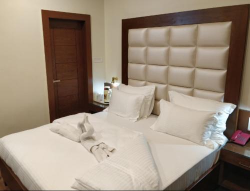 占西Hotel Yatrik的一张配有白色床单和枕头的大床