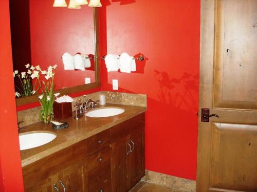 提顿村提顿俱乐部酒店的浴室设有两个水槽和红色的墙壁