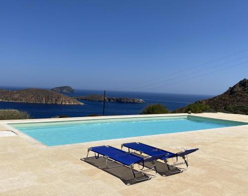 RámosSerifos Stone Villa A的游泳池旁设有2把蓝色躺椅