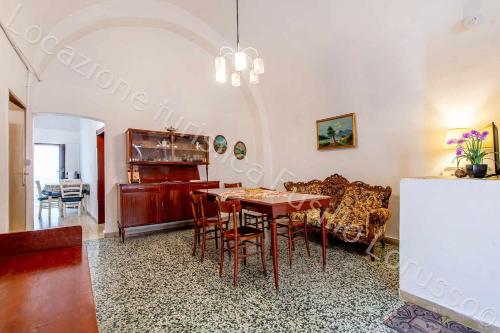 安德里亚Locazione turistica Lorusso 1的一间带桌椅的用餐室