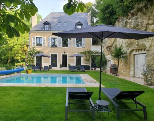 朗热Domaine du Val Sauvage的游泳池旁的遮阳伞和椅子