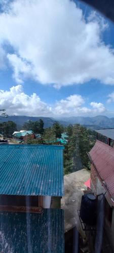 西姆拉Shorya Regency的享有蓝色屋顶建筑的景色