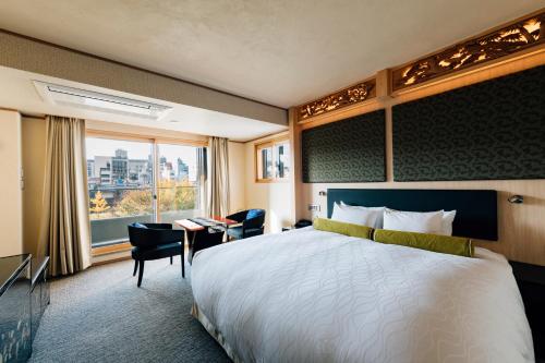 京都京都雅然居酒店的配有一张床、一张书桌和一扇窗户的酒店客房