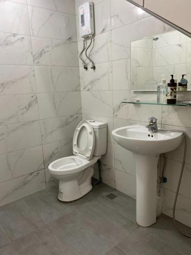 龙井东海牛棚背包客栈的白色的浴室设有卫生间和水槽。