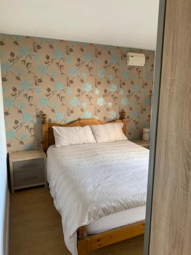 East BridgfordArkenfield farm cabin的一间卧室配有蓝色和棕色壁纸的床