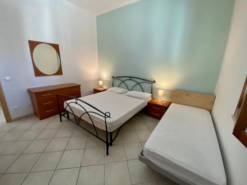 福洛尼卡appartamento Via Siena 1的一间卧室设有两张床,墙上设有一面镜子
