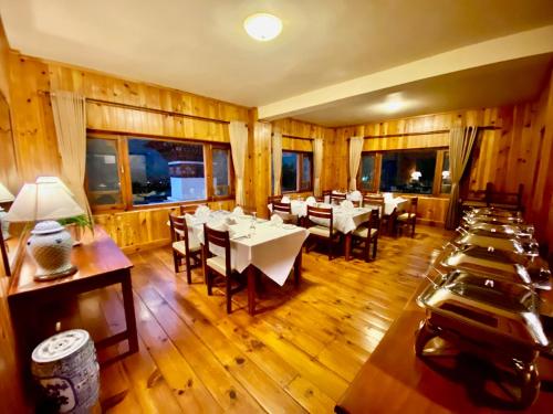 帕罗Taktsang Village Resort的用餐室设有桌椅和窗户。