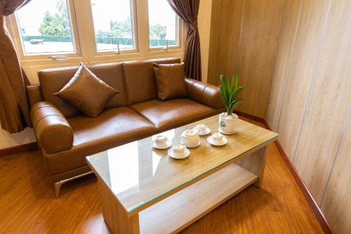 邦美蜀晃禄酒店的客厅配有棕色沙发和茶几