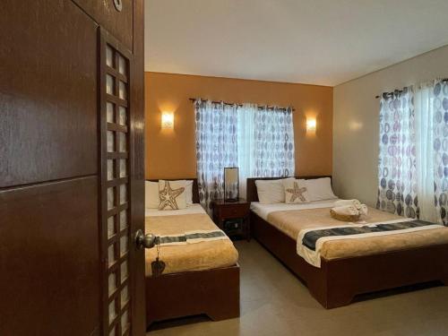 科隆Casa Coron Hotel的酒店客房设有两张床和窗户。