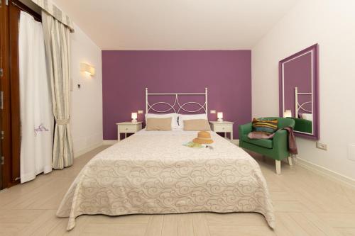 马蒂纳塔伊尔波尔图住宅酒店的一间卧室设有一张大床和紫色的墙壁