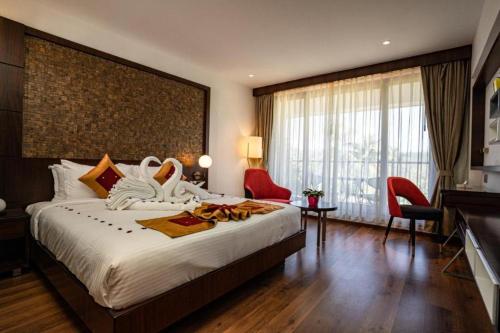 瓦亚纳德Saugandhika West Gate的一间酒店客房,设有一张大床和一个大窗户