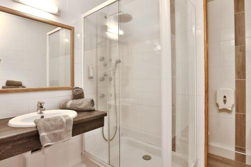 多维勒Hotel Restaurant Logis Le Tropicana的一间带水槽和淋浴的浴室