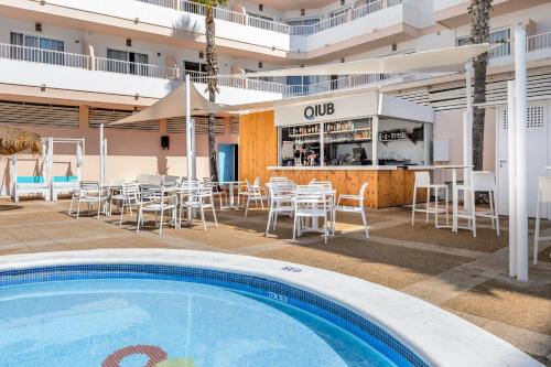 伊维萨镇Apartamentos Vibra Panoramic的一个带游泳池的户外庭院和一间餐厅