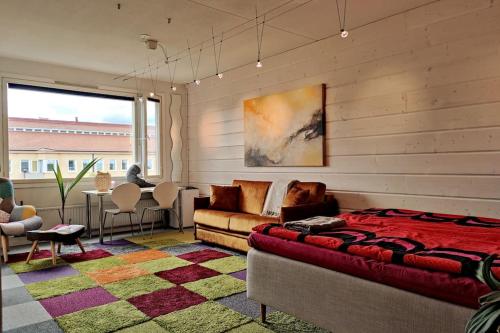 坦佩雷Lovely 7th floor studio full of color, enjoy!的一间卧室配有一张床、一张沙发和一张桌子
