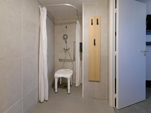 圣萨蒂南B&B HOTEL Le Mans Nord 2的带淋浴和凳子的浴室