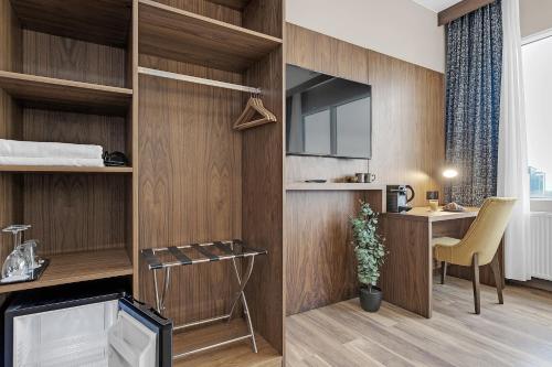 雷克雅未克Alva Hotel的客房设有木墙、书桌和电视。