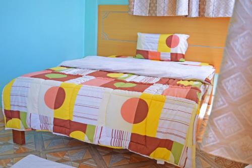 WundanyiTAITA LUXURY HOTELS LTD的一张床上,床上有五颜六色的被子