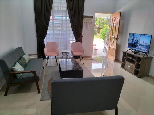 哥打巴鲁Wipah Guest House in Kampung Lundang, Kota Bharu的客厅配有沙发、椅子和电视