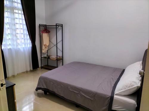 哥打巴鲁Wipah Guest House in Kampung Lundang, Kota Bharu的一间带床的卧室,位于带窗户的房间内