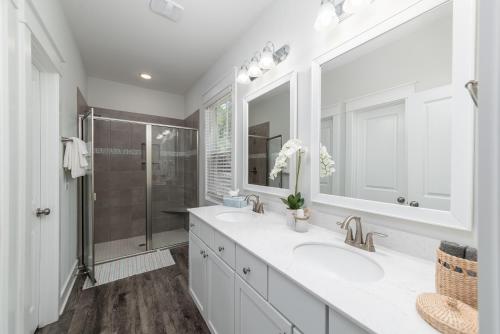 希尔顿黑德岛LUXURY BEACH HOUSE W/ BACKYARD OASIS. HEATED POOL.的白色的浴室设有2个盥洗盆和淋浴。
