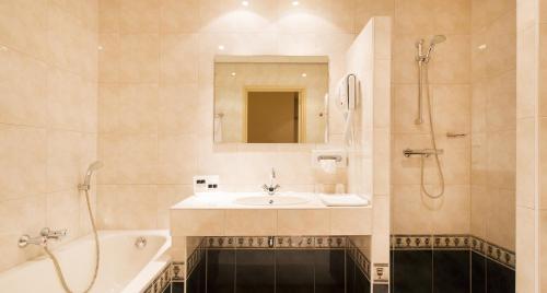 库福尔登库福尔登塔伦斯餐厅酒店的浴室配有水槽、淋浴和浴缸。