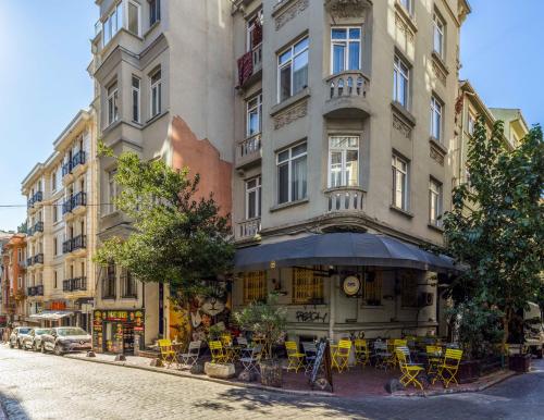 伊斯坦布尔Monnas Suite的街道上一座配有黄色桌椅的建筑