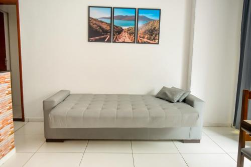 阿拉亚尔-杜卡布Prainha Paradise的墙上有两张照片的房间的一张床位