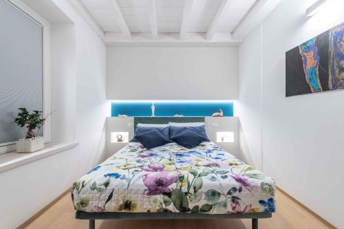 奥托纳Le Dimore的一间卧室配有一张带花卉棉被的床