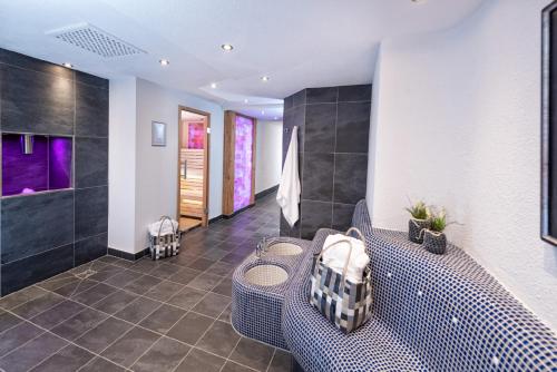 上施陶芬Concordia Vitalhotel & SPA的浴室设有长凳和带紫色灯的淋浴。