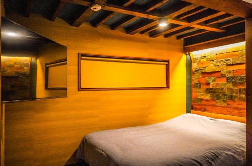 日光Nikko Cottage Yurt的一间卧室配有一张黄色墙壁的床