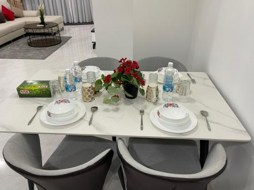 吉隆坡Eaton Residences KLCC by Luna的一张带盘子和鲜花的白色桌子