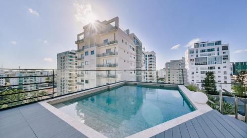 圣多明各Fully Serviced Apartment at Regatta Living II - 6C的大楼阳台上的游泳池