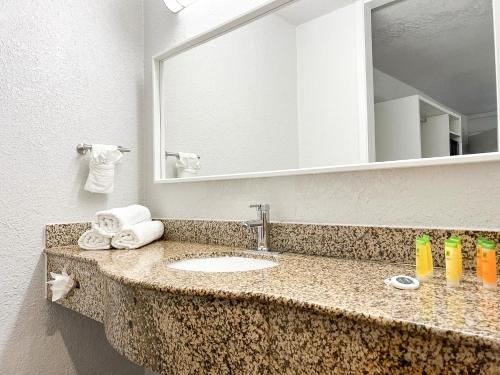 萨凡纳Oneway Savannah的浴室的柜台设有水槽和镜子