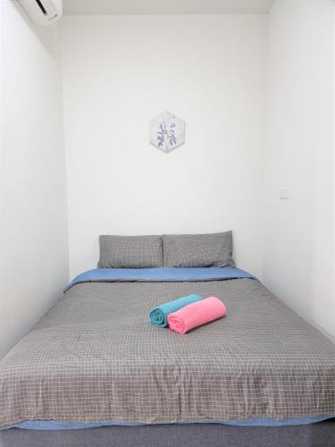 吉隆坡Studio at The Ridge KL East J的一张带两个粉红色和蓝色枕头的床