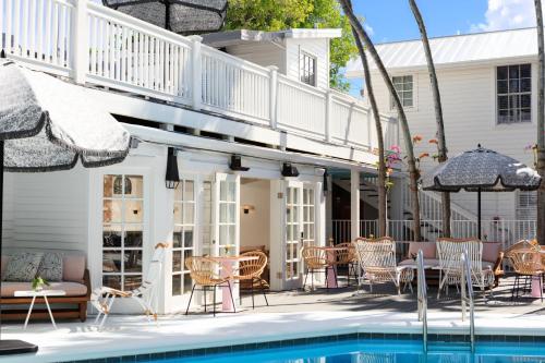 基韦斯特Lighthouse Hotel - Key West Historic Inns的一个带游泳池、椅子和房子的庭院