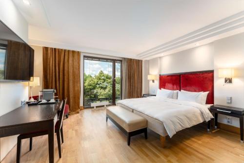 里加里加伊丽莎白丽笙布鲁酒店的酒店客房设有一张大床、一张书桌和一张书桌。