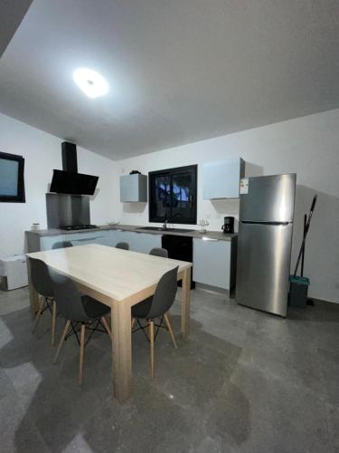 La RivièreL’étoilée的厨房配有桌子和不锈钢冰箱。