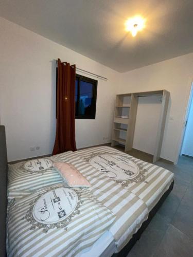 La RivièreL’étoilée的一间卧室配有带条纹毯子的床