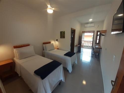 乌巴图巴Caminho da areia的酒店客房设有两张床和一个阳台。