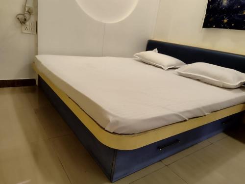 浦那Just homes 2 bhk Service appt的一张带白色床单和枕头的床