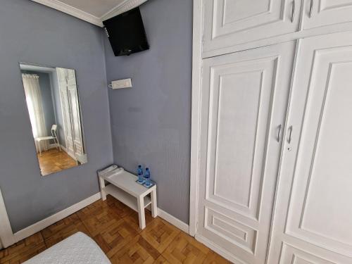 奥维多菲达尔戈旅馆的一间设有白色桌子和镜子的客房