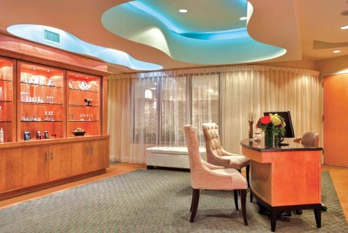 韦斯特伯里Viana Hotel and Spa, Trademark Collection by Wyndham的客房设有一张桌子和一张床,拥有蓝色的天花板