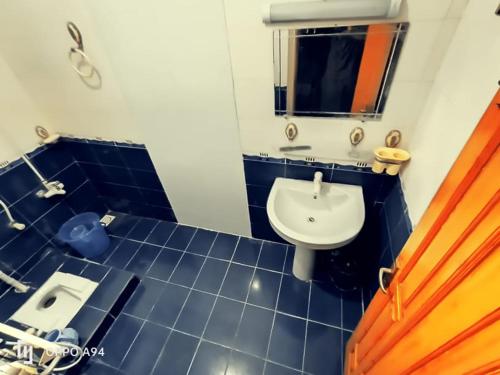 伊斯兰堡Galaxy Lodge的蓝色瓷砖浴室设有水槽和镜子