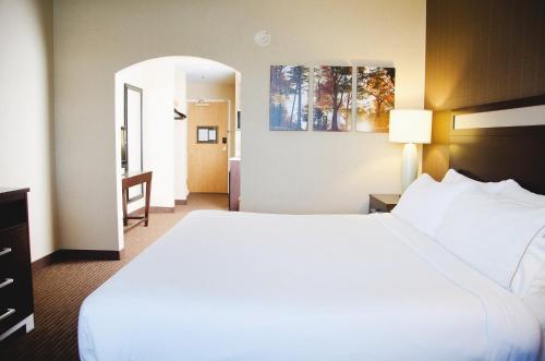 沃特敦沃特敦千岛群岛快捷假日酒店及套房 的一间酒店客房,设有一张大床和一个走廊