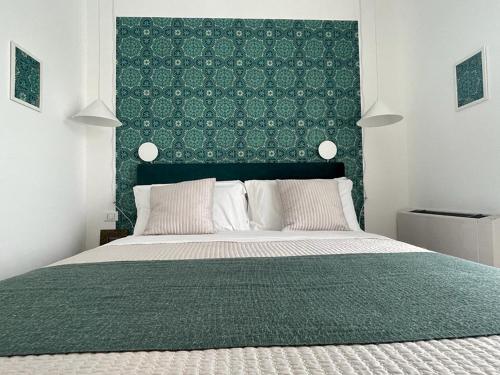博洛尼亚Tecnopolo Fiera Suite的一间卧室配有一张大床和绿色床头板